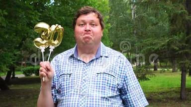 大个子拿着金色气球，把30号放在户外。 30周年庆祝晚会